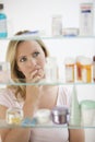 Woman Looking in Medicine Cabinet Royalty Free Stock Photo