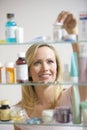 Woman Looking in Medicine Cabinet Royalty Free Stock Photo
