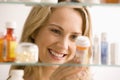 Woman Looking in Medicine Cabinet Royalty Free Stock Photo