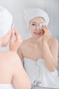 Woman looking mirror and cleaning her face with cotton Royalty Free Stock Photo