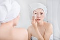 Woman looking mirror and cleaning her face with cotton Royalty Free Stock Photo