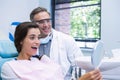 Woman looking at mirror by dentist at medical clinic