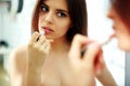Woman looking at mirror while doing makeup Royalty Free Stock Photo