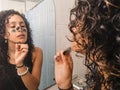 Woman peeling off black facial mask of her face in the bathroom. Royalty Free Stock Photo