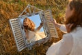 Woman looking into a mirror in a wheat field Royalty Free Stock Photo