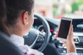 Woman looking at mobile phone while driving a car. Driver using smart phone in car. Royalty Free Stock Photo