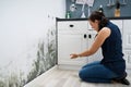 Woman Looking At Mold Wall Damage