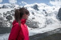 Woman looking at Morteratsch Glacier in the Engadin in the Swiss Alps in summer with blue sky and sun