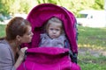 Woman looking at offended little girl sitting in stroller Royalty Free Stock Photo
