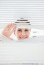 Woman looking out through blinds Royalty Free Stock Photo