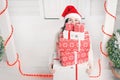 Woman looking out from pile of Christmas gift boxes Royalty Free Stock Photo