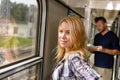 Woman looking out the train window smiling Royalty Free Stock Photo