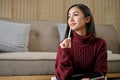 A woman is looking out the window and daydreaming while working on her work in her living room Royalty Free Stock Photo