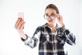 Woman looking over glasses and taking selfie with cell phone Royalty Free Stock Photo