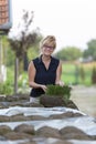 Woman looking at a pallet with stack of sod turf grass rolls, ready for laying in new lawn. Natural grass installation Royalty Free Stock Photo