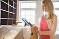 Woman looking at photo frame while unpacking moving boxes at new house Royalty Free Stock Photo