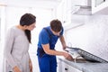 Repairman Fixing Induction Stove In The Kitchen