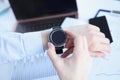 Woman looking at smart watch at workplace closeup