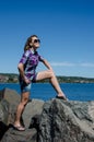 Woman looking smug and happy poses on rocks at the lakewalk in Canal Park Duluth MN