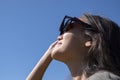 Woman is looking on solar eclipse through three sunglasses. Royalty Free Stock Photo