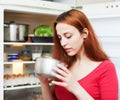 Woman looking for something in pan near fridge Royalty Free Stock Photo