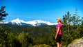 Woman looking at the Tantalus Mountain Range with snow covered peaks of Alpha Mountain, Serratus and Tantalus Mountain