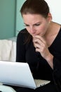 Woman Looking Thoughtfully At Laptop Screen Royalty Free Stock Photo