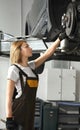 Woman looking at tire of car in auto service Royalty Free Stock Photo