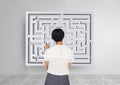 Woman looking to a maze on the wall Royalty Free Stock Photo