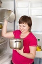 Woman looking in to pan from refrigerator Royalty Free Stock Photo