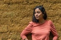 woman looking to the side with an adobe wall