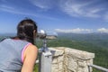 Girl Watching the mountain landscape in the observation binoculars