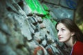 Woman looking up stone wall