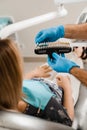 Woman looking at veneers or implants teeth color matching samples in doctor hands. Dentistry. Dentist demonstrate teeth