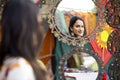 Woman looking into vintage mirror at Surajkund Mela