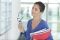 Woman looking at wallplanner with rueful expression