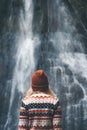 Woman looking at waterfall traveling alone