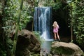 Woman looking at waterfall in tropical rainforest Royalty Free Stock Photo