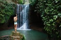 Woman looking at waterfall in tropical rainforest Royalty Free Stock Photo