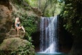 Woman looking at waterfall in tropical rainforest Royalty Free Stock Photo