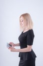 Woman looking in white tablet in her hands. Close up of young blonde beautiful girl in black dress using tablet Royalty Free Stock Photo