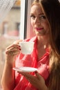 Woman looking through window, relaxing drinking coffee Royalty Free Stock Photo