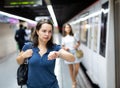 Woman looking at wristwatch at subway station