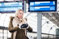 Woman looking at wristwatch in train station as her train has a delay Royalty Free Stock Photo