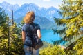 Woman looks at Alpine landscape, Bavaria, Germany. Scenic view to Alpsee lake near Schwangau village