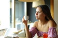 Woman looks away holding coffee in a restaurant Royalty Free Stock Photo