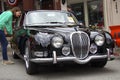 Woman looks at black Jaguar 3.8-litre S- Type (1965) Royalty Free Stock Photo