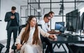 Woman looks into the camera. Team of stockbrokers works in modern office with many display screens Royalty Free Stock Photo