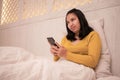 A woman looks confused while using her cellphone