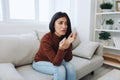 A woman looks at an engagement ring in her hand with sadness and tears, divorce and loss of a partner, breakup, unhappy